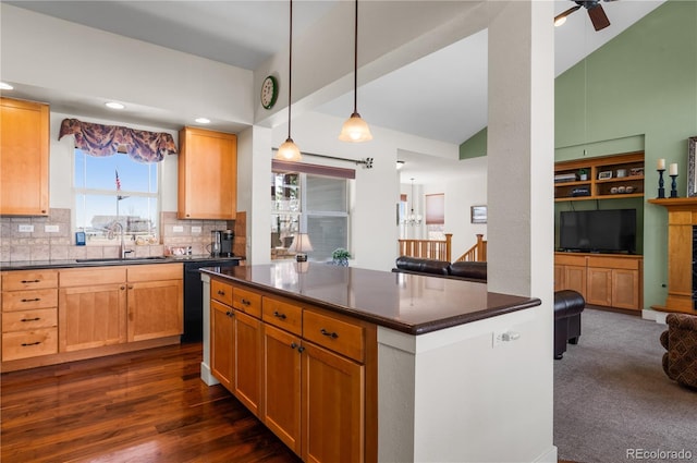 kitchen featuring backsplash, dark countertops, dishwasher, a sink, and ceiling fan