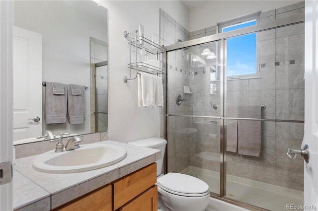 full bath featuring vanity, toilet, and a stall shower
