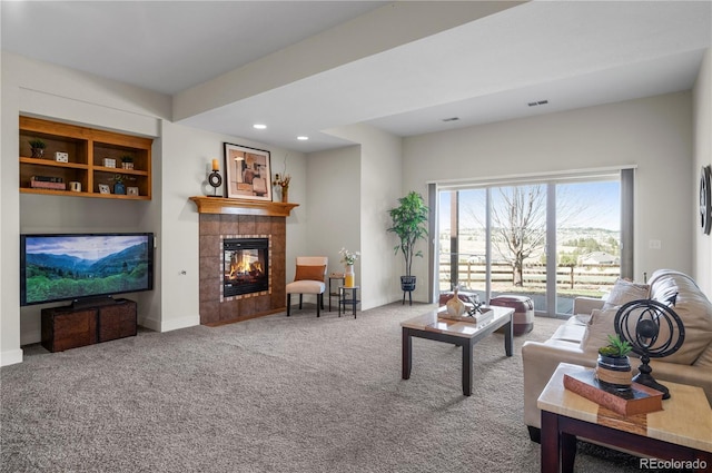 carpeted living room with baseboards, recessed lighting, visible vents, and a tiled fireplace