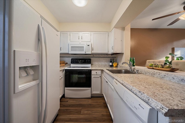 kitchen with white appliances, dark wood-style flooring, a sink, white cabinetry, and tasteful backsplash