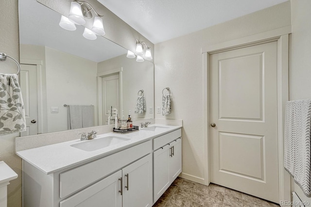 bathroom with double vanity, baseboards, and a sink