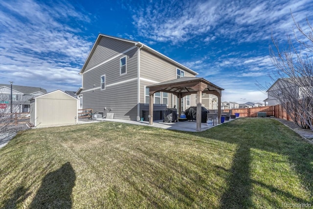 rear view of property with a gazebo, a patio, a storage unit, and a yard