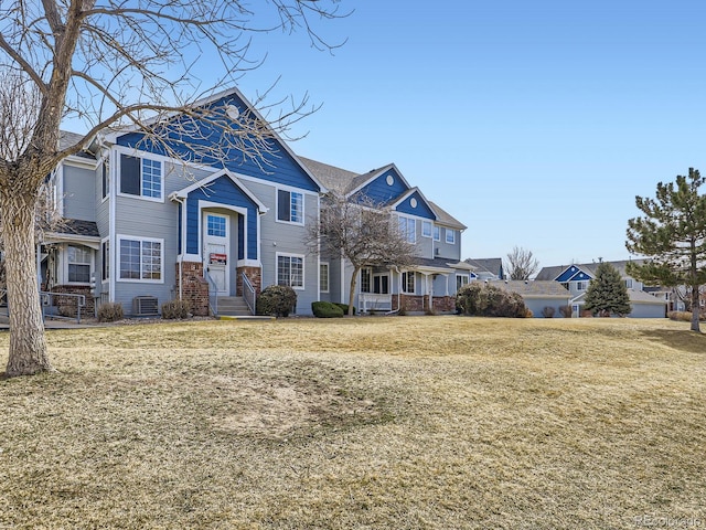 view of front of property featuring a front lawn, central air condition unit, and a residential view