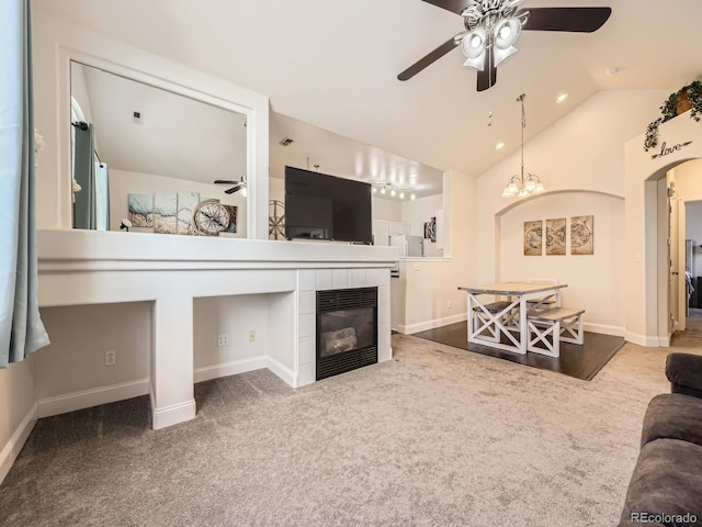 living area with arched walkways, carpet flooring, a tiled fireplace, and lofted ceiling