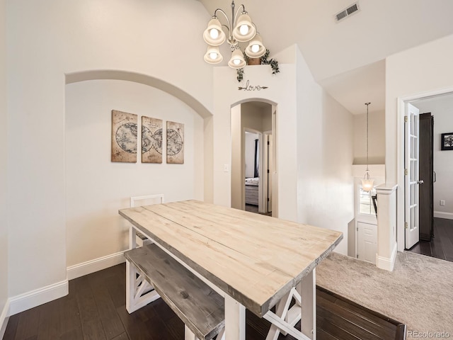 dining space featuring visible vents, baseboards, an inviting chandelier, and dark wood-style floors