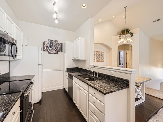 kitchen with visible vents, a peninsula, dark wood-style flooring, stainless steel appliances, and a sink