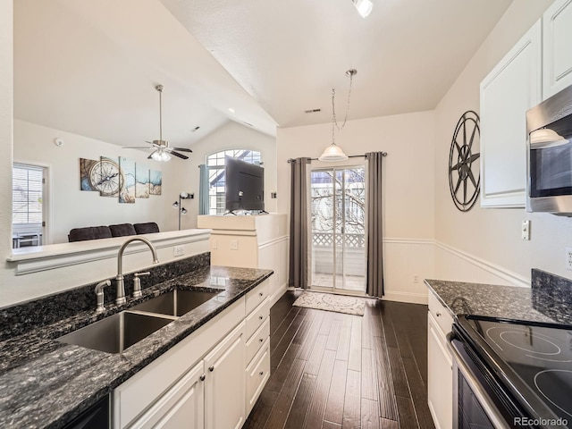 kitchen featuring stainless steel microwave, range with electric stovetop, dark wood-style floors, white cabinets, and a sink