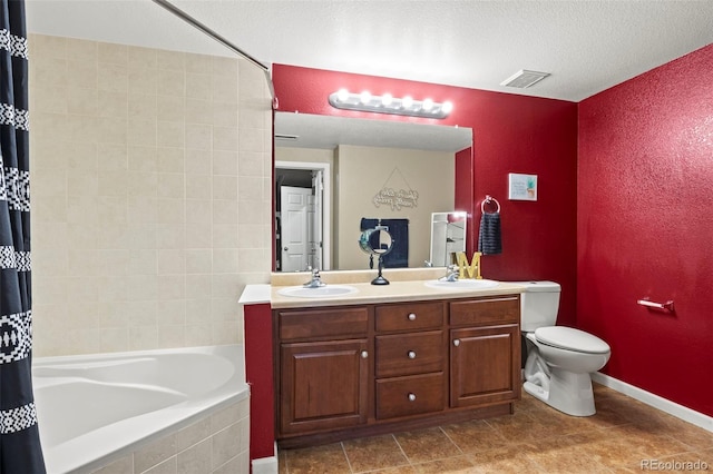 full bathroom featuring vanity, toilet, shower / bath combo with shower curtain, and a textured ceiling