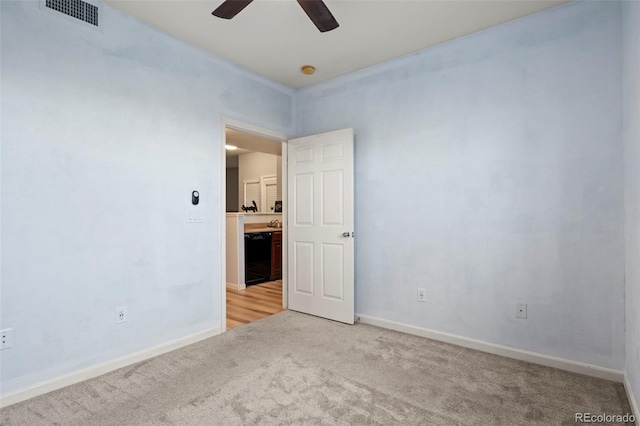 carpeted spare room featuring ceiling fan