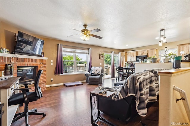 1115 Cherry Ct, Fort Lupton, CO 80621 - living room featuring wood finished floors, ceiling fan, a textured ceiling, and a fireplace