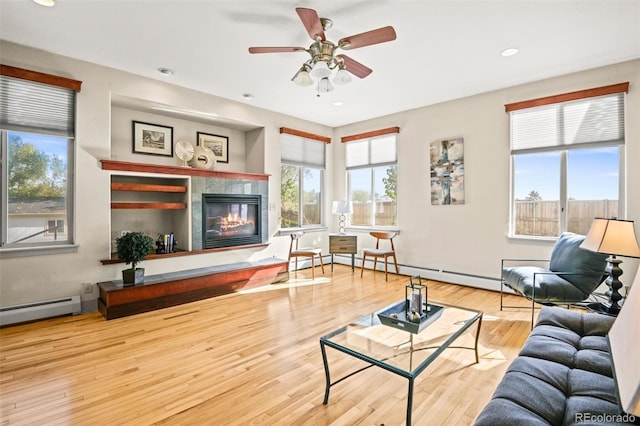 living room with hardwood / wood-style flooring, a baseboard radiator, and ceiling fan