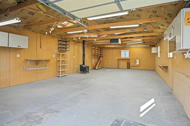 garage with a wood stove and wood walls