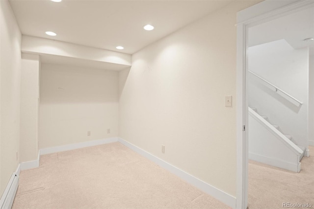 basement with a baseboard radiator and light colored carpet