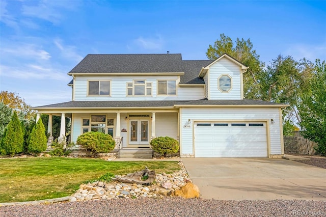 view of front of home with covered porch, a front yard, and a garage