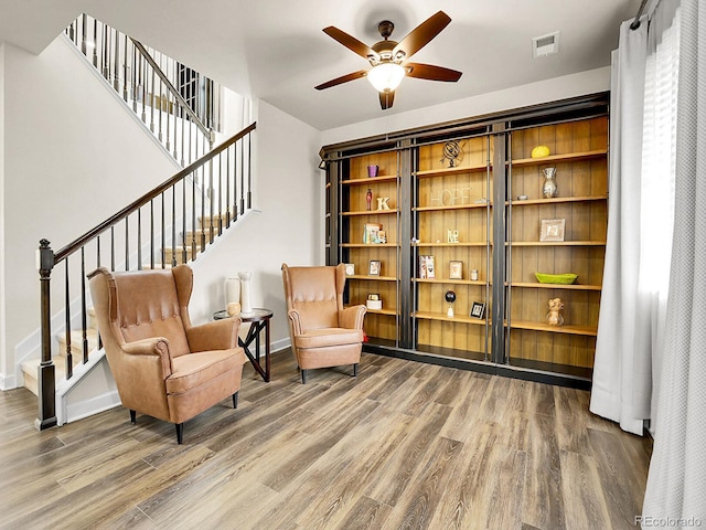 9844 Truckee St, Commerce City, CO 80022 - sitting room featuring wood finished floors, visible vents, stairs, and a ceiling fan