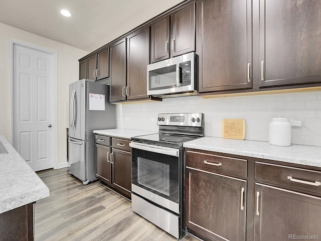9844 Truckee St, Commerce City, CO 80022 - kitchen with recessed lighting, stainless steel appliances, backsplash, dark brown cabinets, and light wood-type flooring