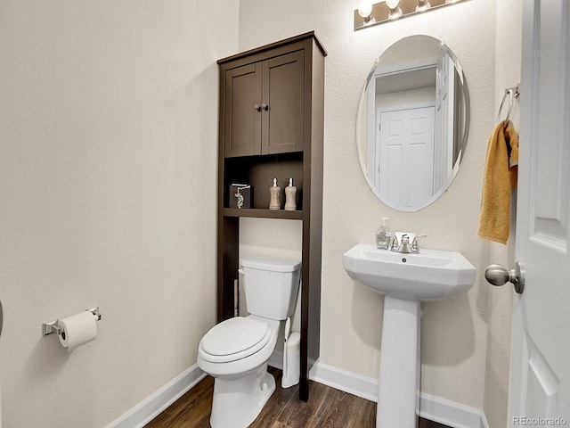 9844 Truckee St, Commerce City, CO 80022 - bathroom featuring a sink, toilet, wood finished floors, and baseboards