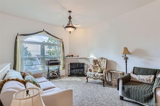 living room featuring a tile fireplace and carpet floors