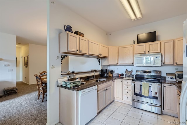 kitchen with white appliances, light colored carpet, sink, light brown cabinets, and dark stone countertops