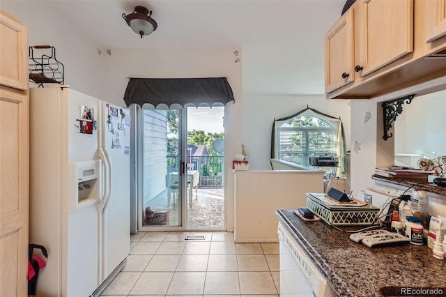 interior space featuring a wealth of natural light, light brown cabinets, and white refrigerator with ice dispenser