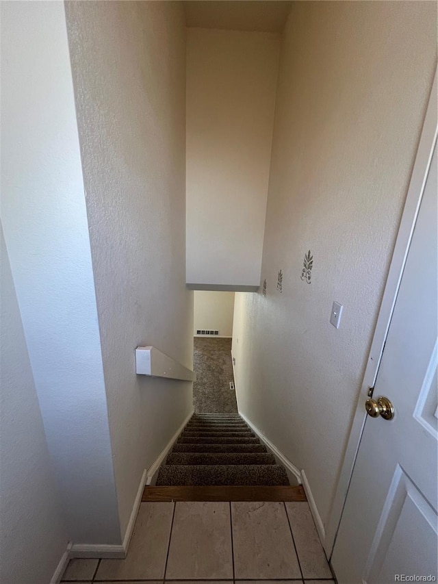 stairs featuring tile patterned floors and baseboards