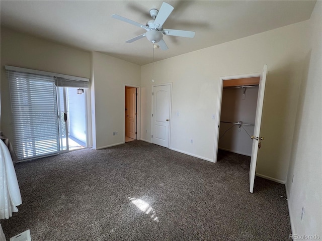 unfurnished bedroom with ceiling fan, a spacious closet, visible vents, carpet flooring, and baseboards