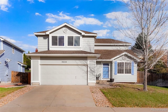 view of property with a garage and a front lawn