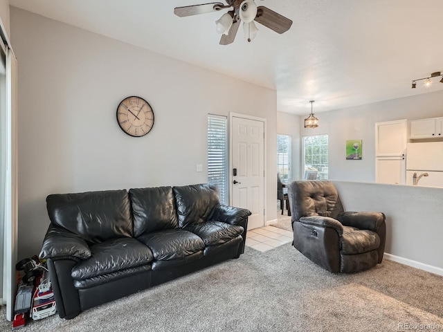 carpeted living area featuring baseboards and ceiling fan