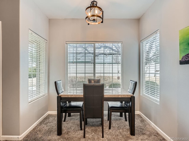 dining room with an inviting chandelier, carpet flooring, and baseboards