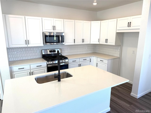 kitchen with white cabinetry, appliances with stainless steel finishes, sink, and decorative backsplash