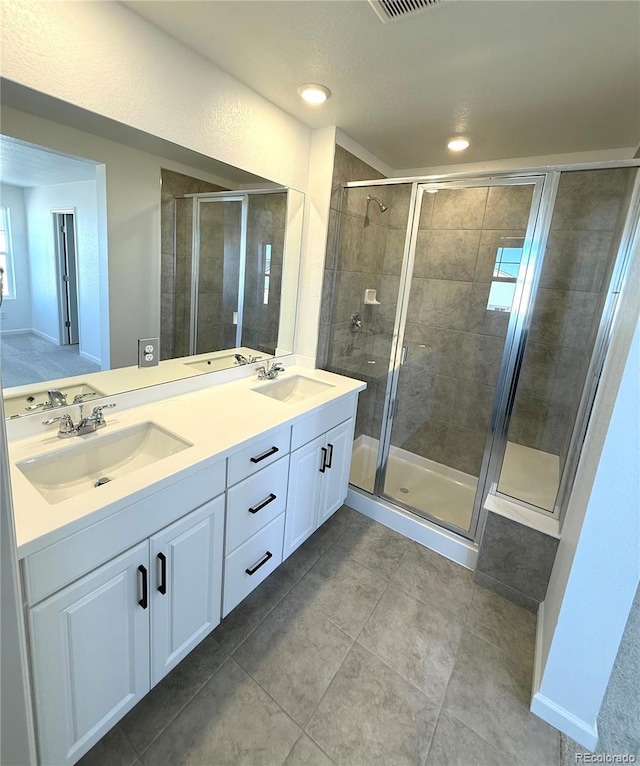 bathroom featuring vanity, tile patterned flooring, and walk in shower