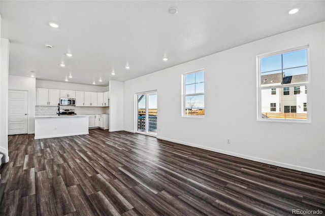 3282 N Catawba Way, Aurora, CO 80019 - unfurnished living room with a healthy amount of sunlight and dark hardwood / wood-style flooring