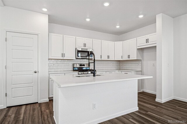 3282 N Catawba Way, Aurora, CO 80019 - kitchen featuring stainless steel appliances, dark hardwood / wood-style floors, a center island with sink, and white cabinets