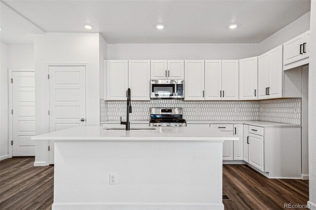 3282 N Catawba Way, Aurora, CO 80019 - kitchen with sink, dark hardwood / wood-style flooring, stainless steel appliances, a kitchen island with sink, and white cabinets