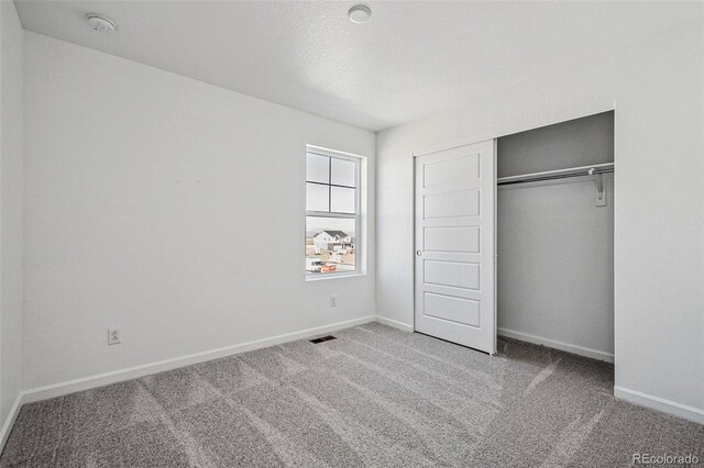 3282 N Catawba Way, Aurora, CO 80019 - unfurnished bedroom featuring a closet, a textured ceiling, and carpet flooring