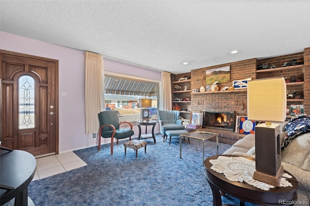 tiled living room featuring built in shelves, a brick fireplace, and a textured ceiling