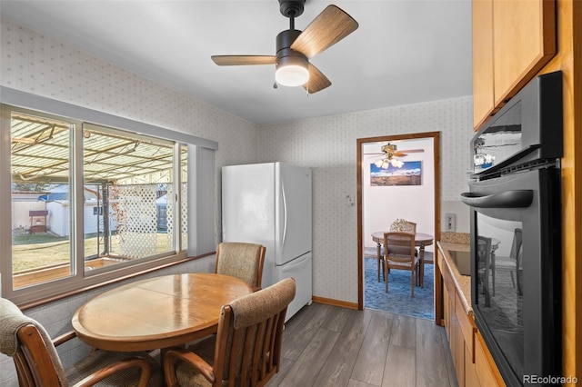 dining area with ceiling fan and dark hardwood / wood-style floors