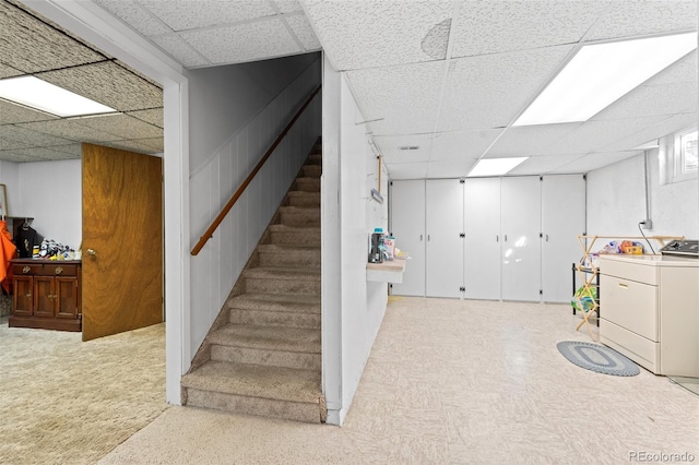 basement with a drop ceiling and washer / clothes dryer