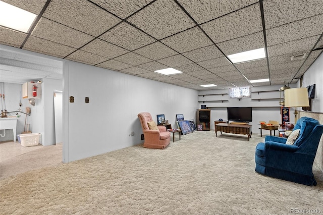 unfurnished living room featuring sink, a paneled ceiling, and carpet flooring