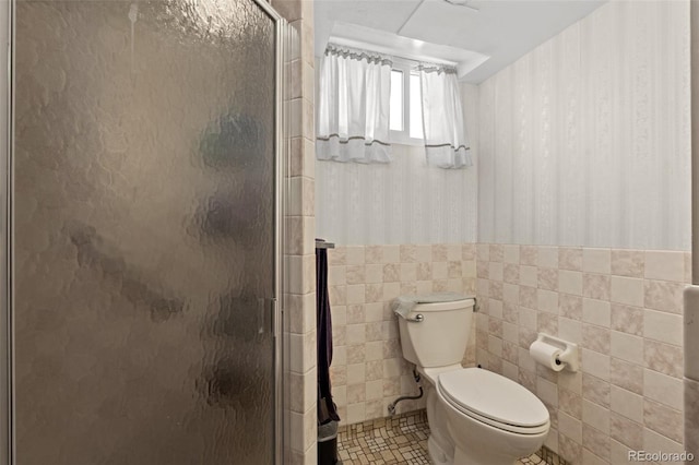 bathroom featuring tile walls, tile patterned floors, a shower with door, and toilet