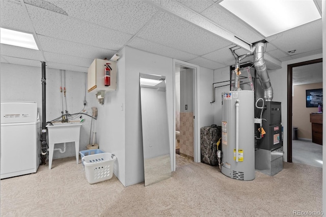 basement featuring a paneled ceiling, washer / clothes dryer, sink, and gas water heater