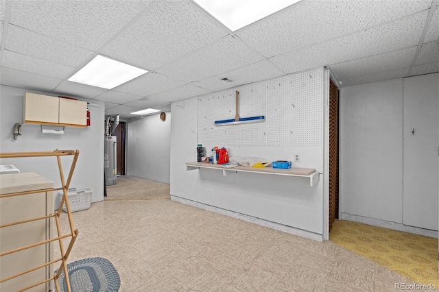 basement featuring water heater and a paneled ceiling