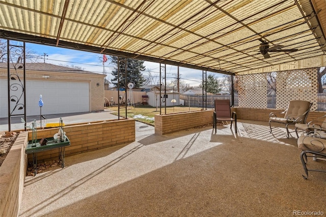 view of patio / terrace featuring a garage and ceiling fan