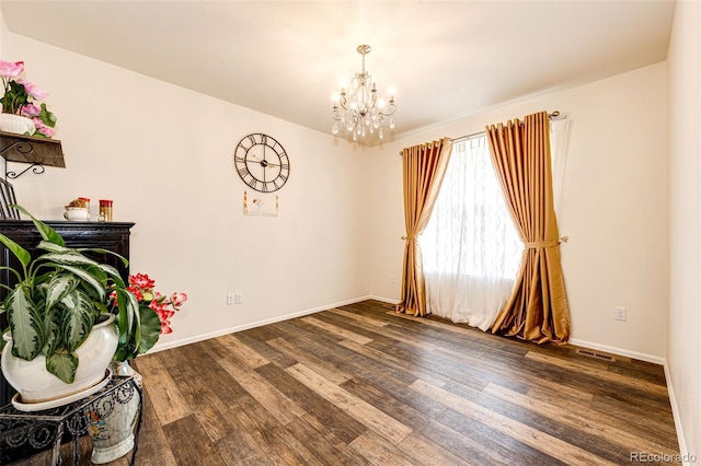 interior space with a chandelier, wood finished floors, and baseboards