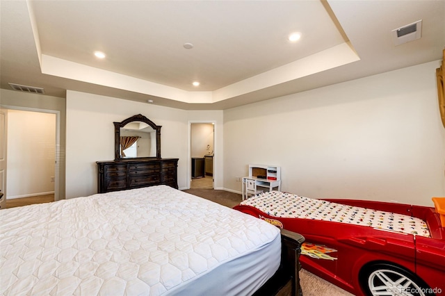 carpeted bedroom with visible vents, a raised ceiling, and recessed lighting