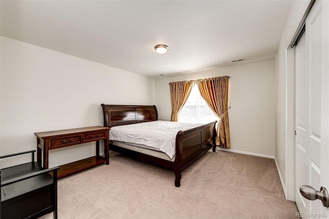 bedroom with light carpet, a closet, visible vents, and baseboards