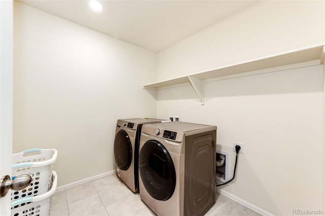 laundry room featuring light tile patterned floors, laundry area, separate washer and dryer, and baseboards