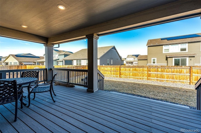 wooden terrace featuring a residential view and a fenced backyard