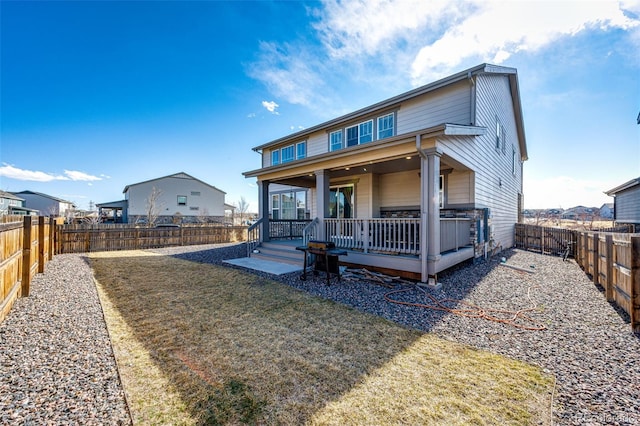 back of house with a fenced backyard and a yard