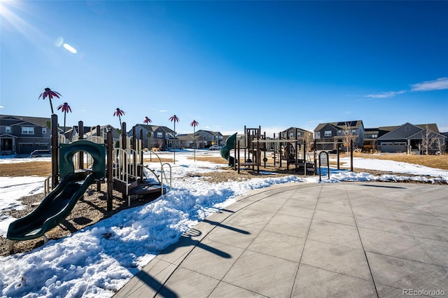 snow covered playground with a residential view and playground community